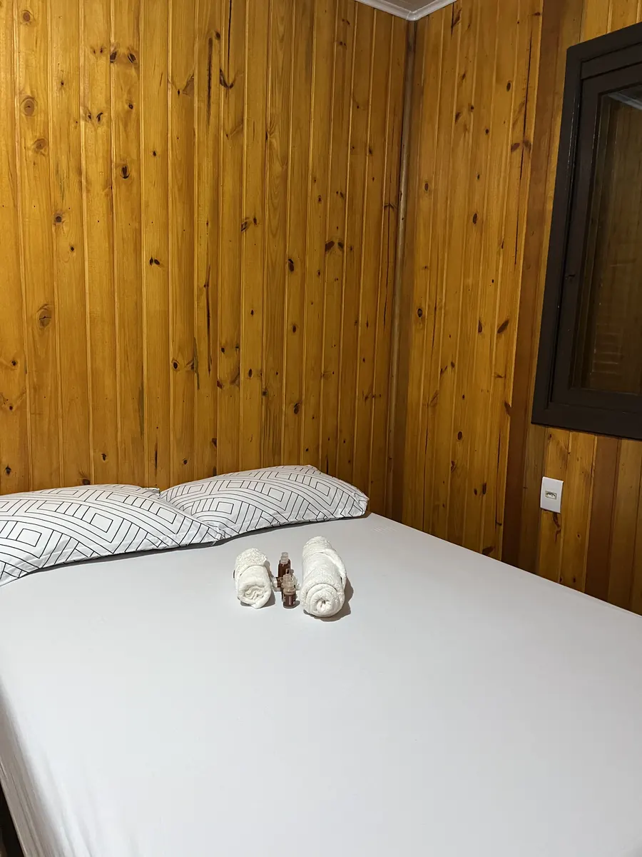 Cama preparada com toalhas na Cabana Aconchego